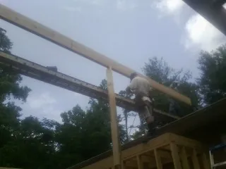 Carpenter setting a ridge beam over a new addition frame — Ice Dam Removal by Roofing Brothers in North Andover