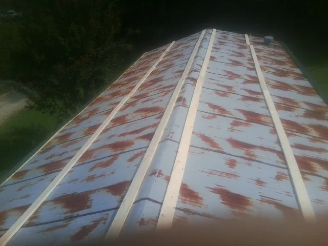 Rusted metal roof panels with new wood purlins before replacement — Storm Damage Roof Repair in North Andover by Roofing Brothers