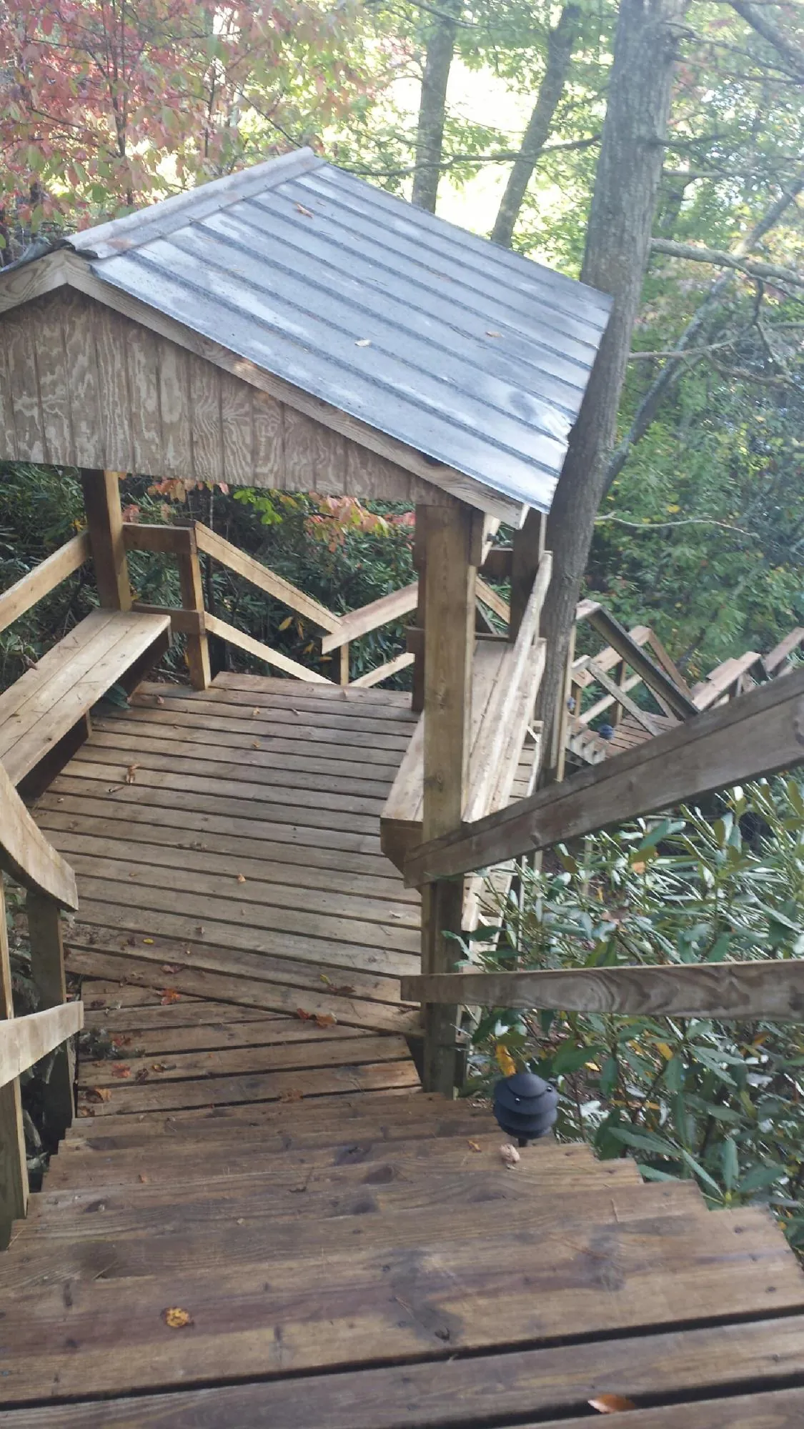 Metal roofed shelter over wooden steps on a wooded walkway — Skylight Repair & Installation work by our crew in North Andover
