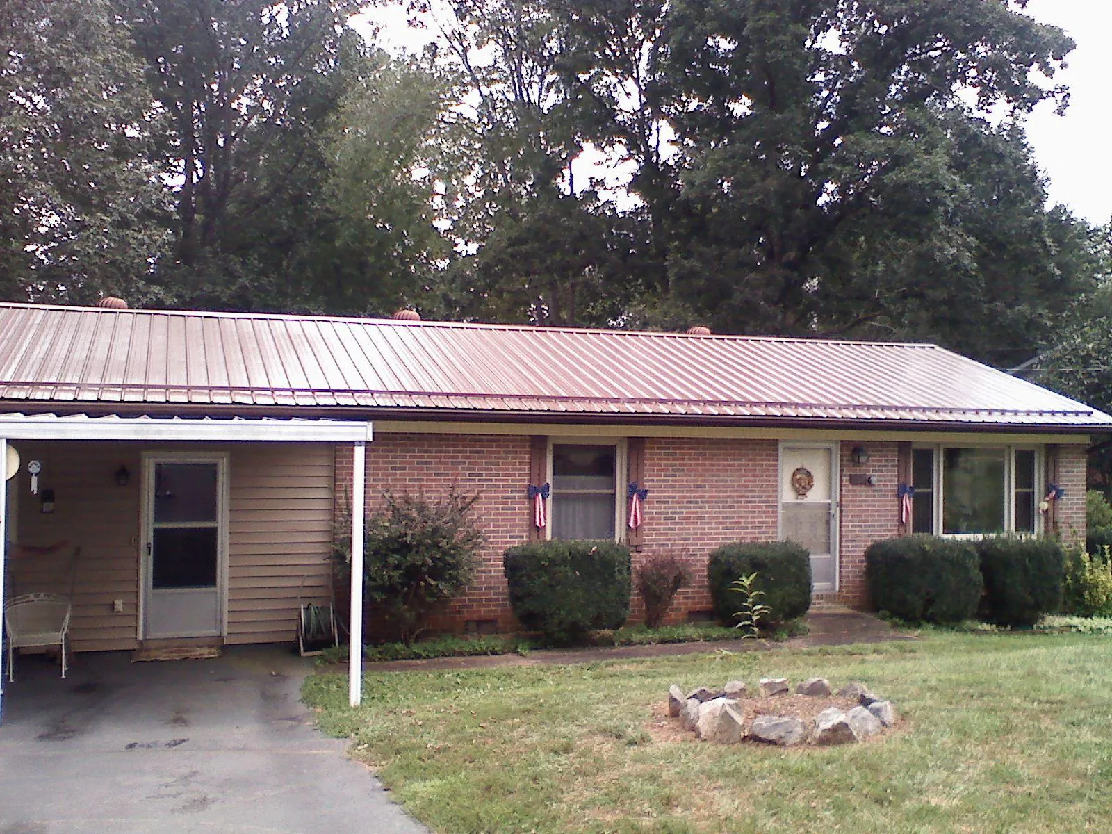 Bronze metal roof and carport on a brick ranch home — Roof Repair work by our crew in North Andover